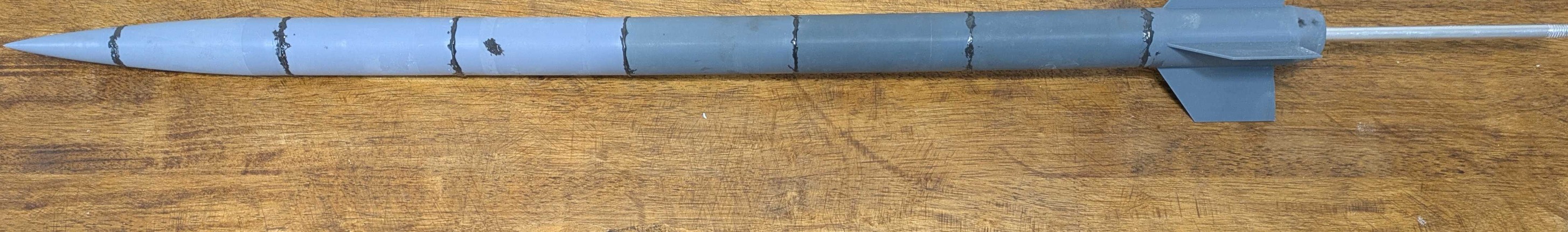 CAD-modeled rocket prepared for wind tunnel testing on a rod fixture